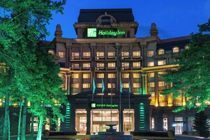 Un edificio de varios pisos con un llamativo letrero de 'Holiday Inn' en la parte superior.