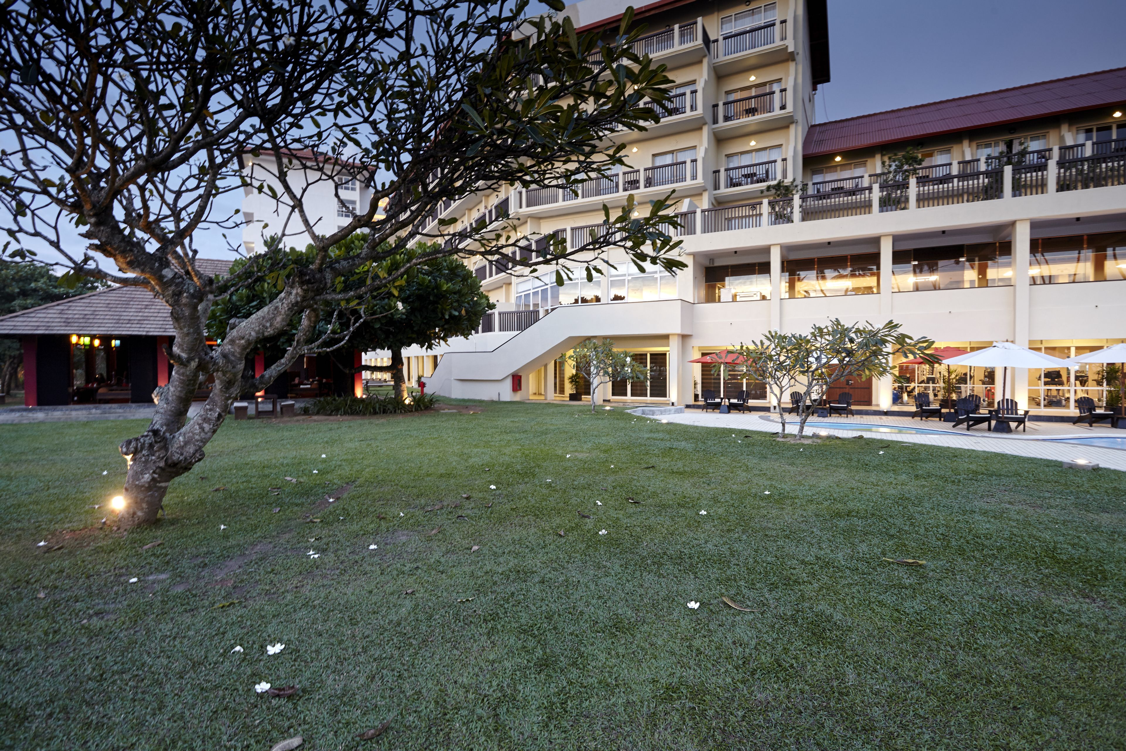 Um hotel com um pátio central, área de estar ao ar livre e um edifício de vários andares com sacadas.