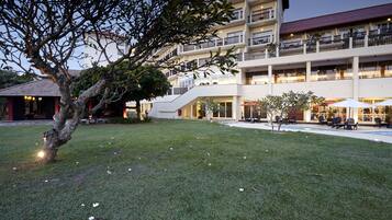 Um hotel com um pátio central, área de estar ao ar livre e um edifício de vários andares com sacadas.