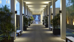 A covered walkway with benches and potted plants, leading to a building entrance. - Turyaa Kalutara (Wadduwa)
