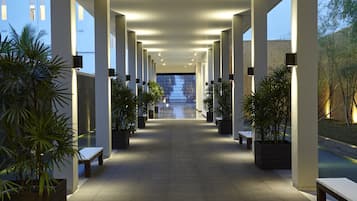 Guests can walk along the corridor, passing by benches and potted plants.