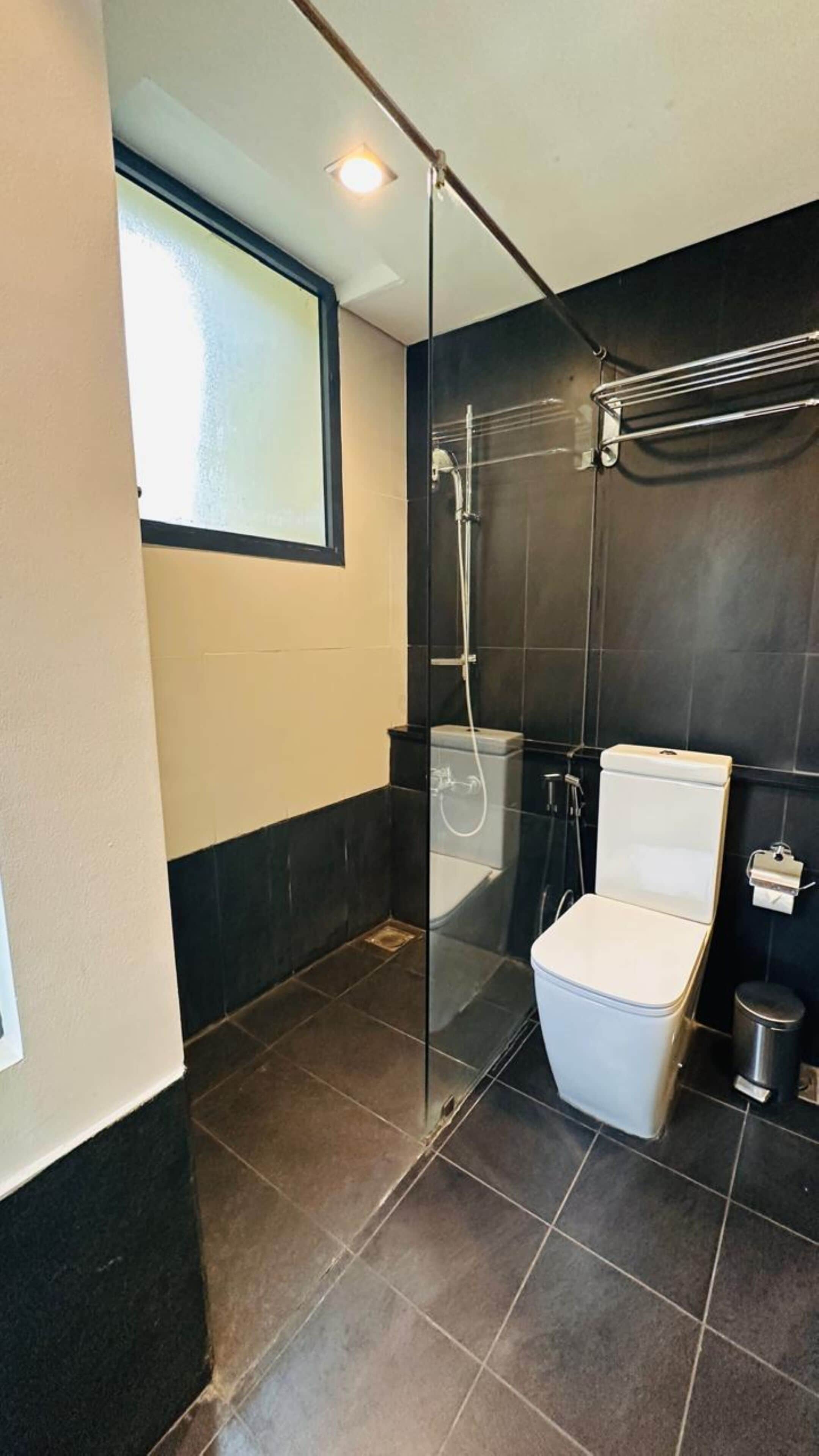 Un baño moderno con ducha envuelta en vidrio, inodoro y bidé.