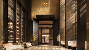 A spacious lobby with a modern design, featuring a central seating area, a large chandelier, and a view into the hotel's interior. - Rosewood Beijing (Beijing)
