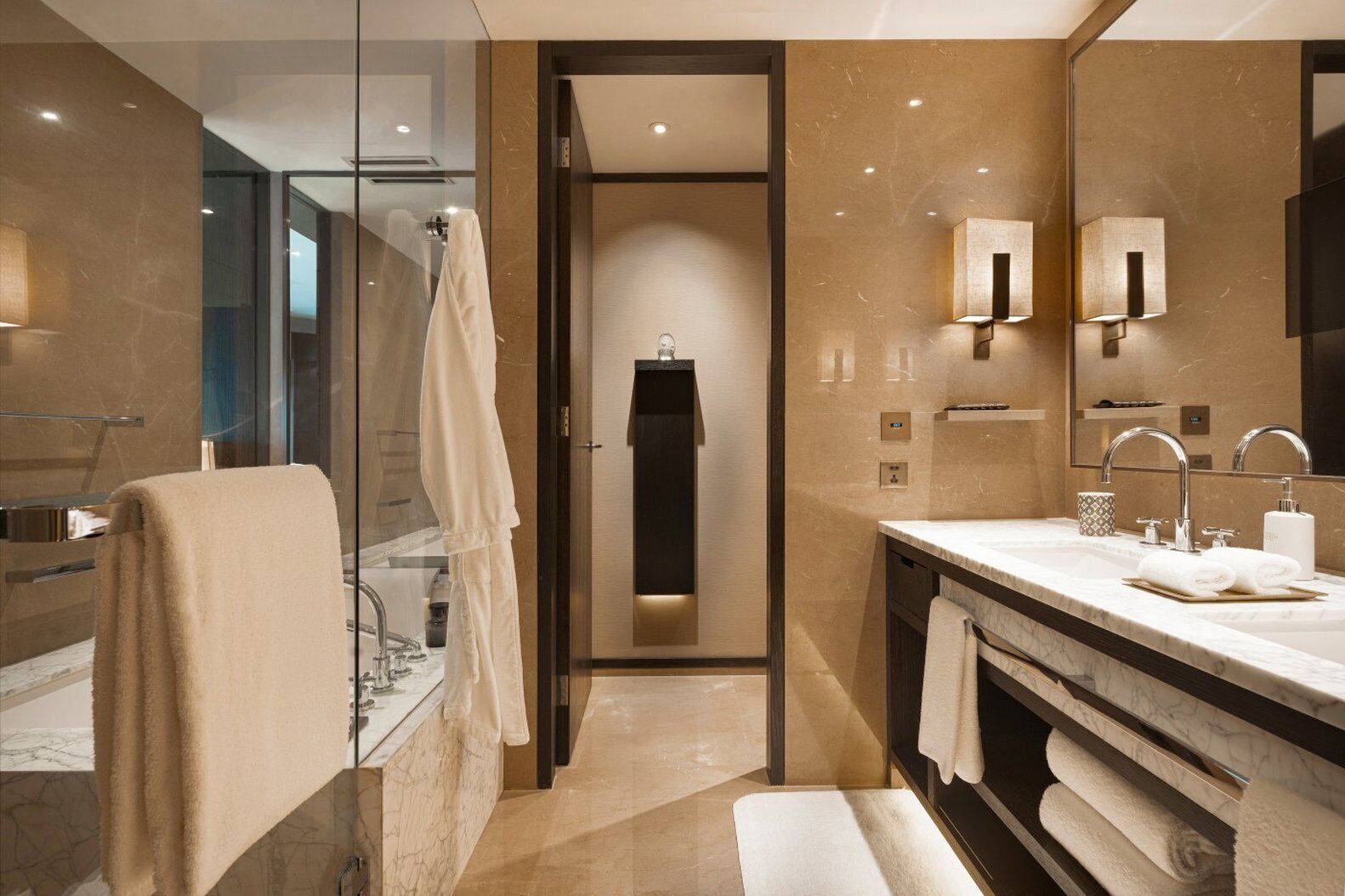 A modern bathroom with a glass shower enclosure, a vanity with a large mirror, and a towel rack.
