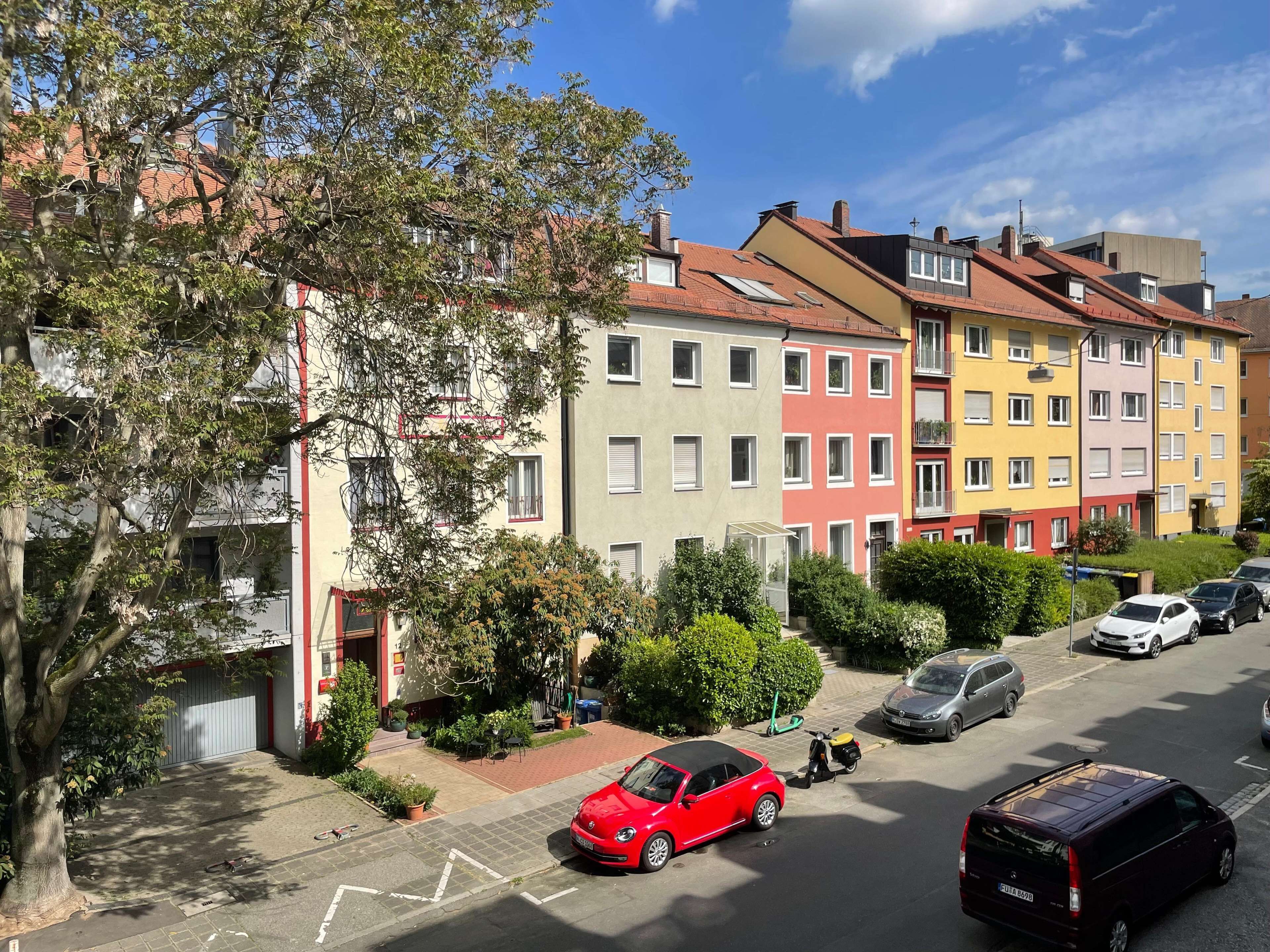 A row of colorful apartment buildings with a red car parked in front.