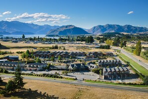 A residential area with multiple apartment buildings, a road, and mountains in the background. - Oakridge Resort Lake Wanaka (Wanaka)