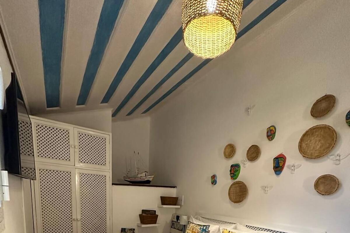 A bedroom with a bed, bedside tables, a wardrobe, and decorative wall art.