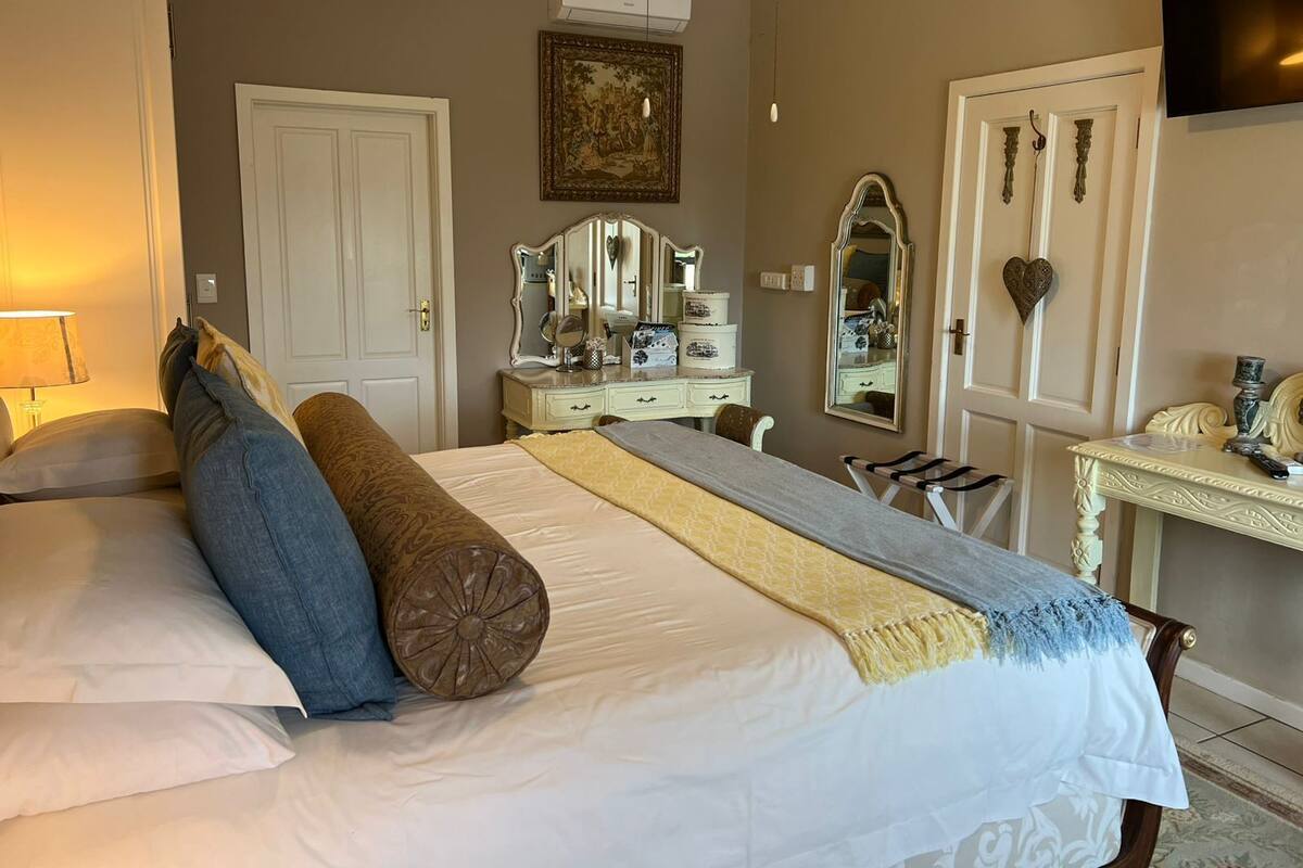 Ein Schlafzimmer mit einem Bett, einem Schminktisch und einem Spiegel.