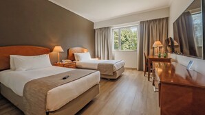 A hotel room with two beds, a desk, and a large window. - Hotel Agua del Desierto (Calama)