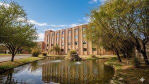 A modern building with a reflective water feature in front. - Hotel Agua del Desierto (Calama)