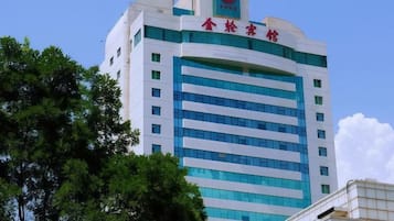 Un edificio de varios pisos con un llamativo letrero rojo y blanco en la parte superior.