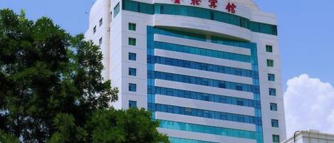 A multi-story building with a prominent red and white sign at the top.