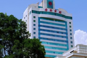 A multi-story building with a prominent red and white sign at the top. - Golden Lun Hotel (Lanzhou)