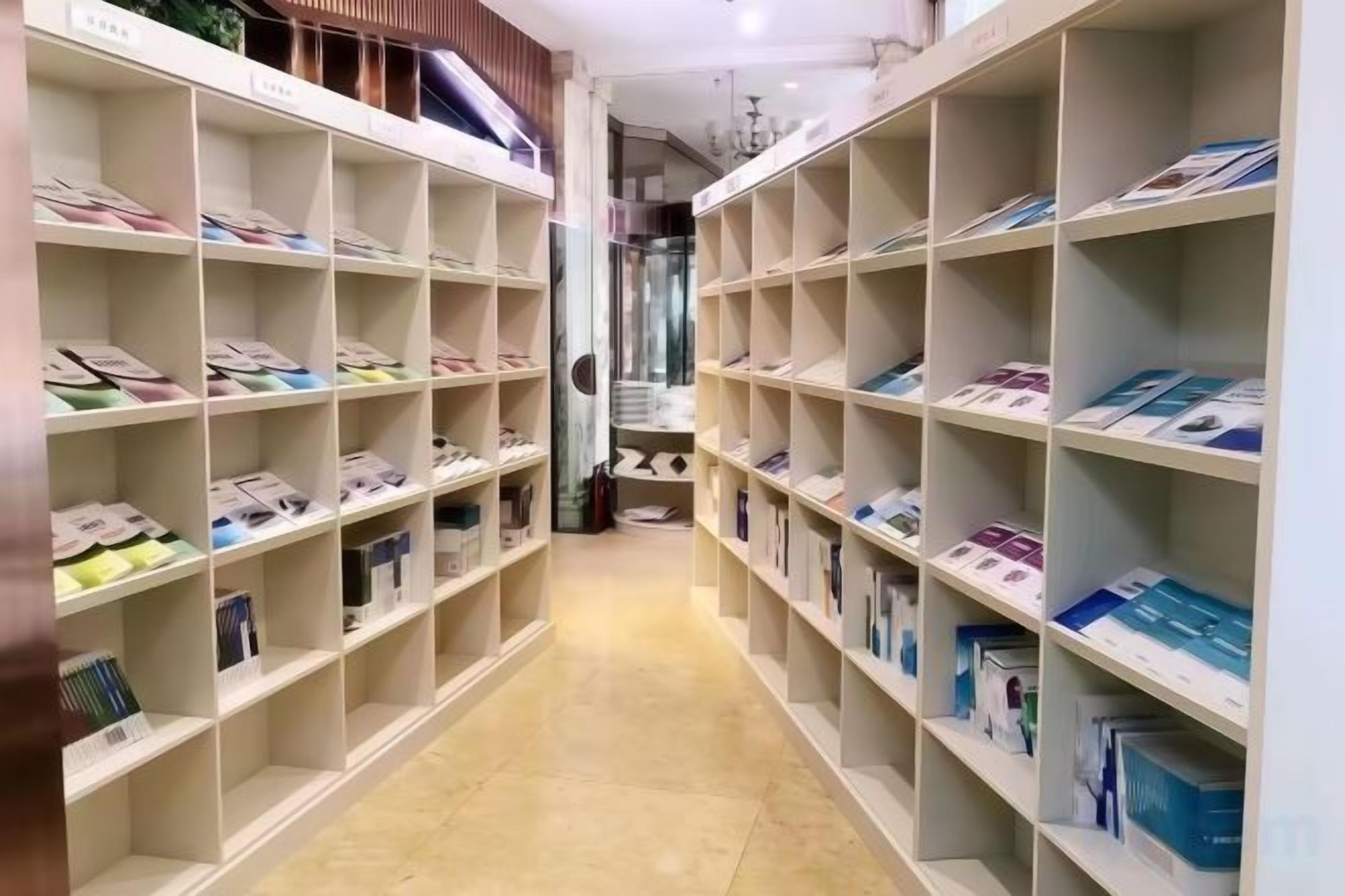 Un pasillo con estanterías a ambos lados, donde se observan cajas y paquetes ordenados.