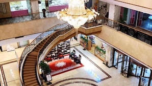 A multi-level hotel lobby with a grand chandelier, a central seating area, and a staircase. - Golden Lun Hotel (Lanzhou)