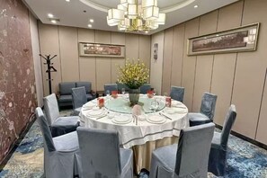 A conference room with a round table, chairs, and a chandelier. - Golden Lun Hotel (Lanzhou)