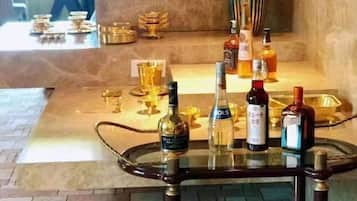 A bar area with a glass table displaying bottles and glasses.