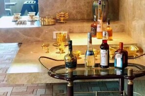 A bar area with a glass table displaying bottles and glasses. - Golden Lun Hotel (Lanzhou)