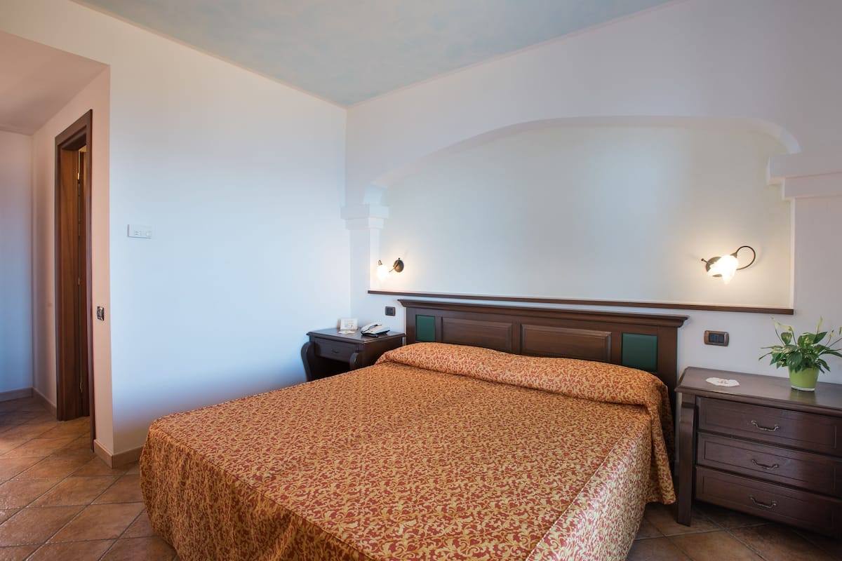 Ein Schlafzimmer mit Bett, Nachttisch und einer Wandleuchte.