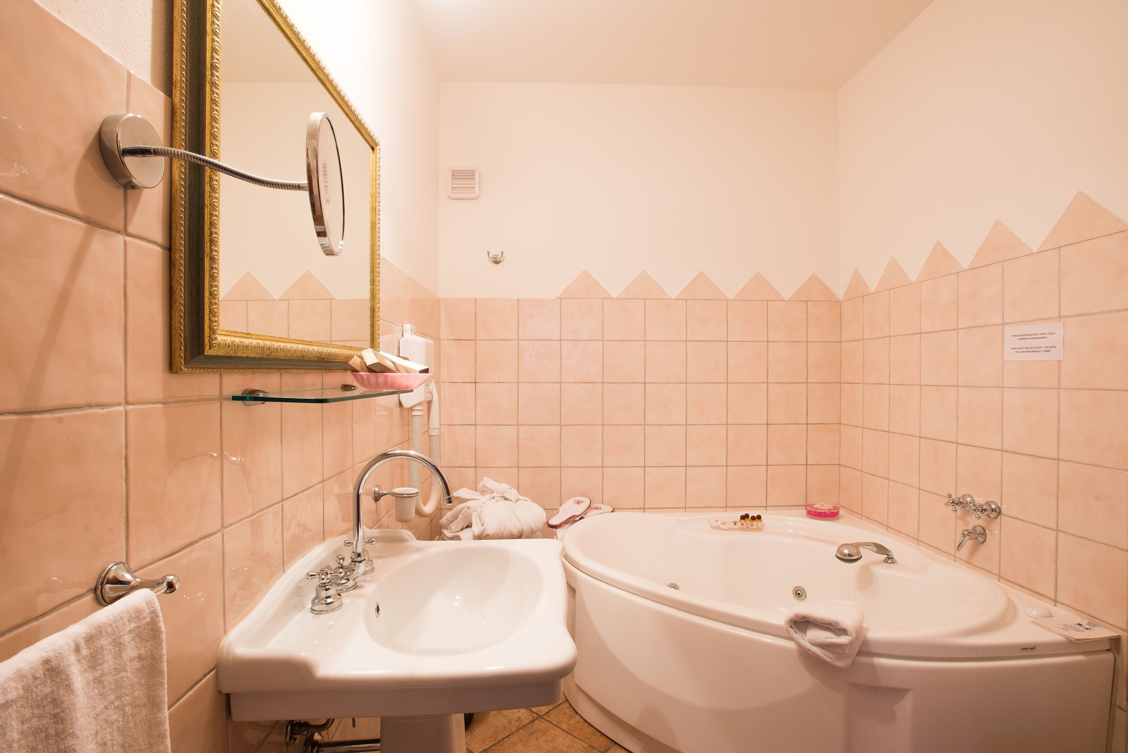 A bathroom with a sink, mirror, and bathtub.