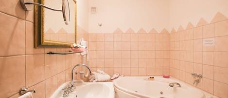 A bathroom with a sink, mirror, and bathtub.