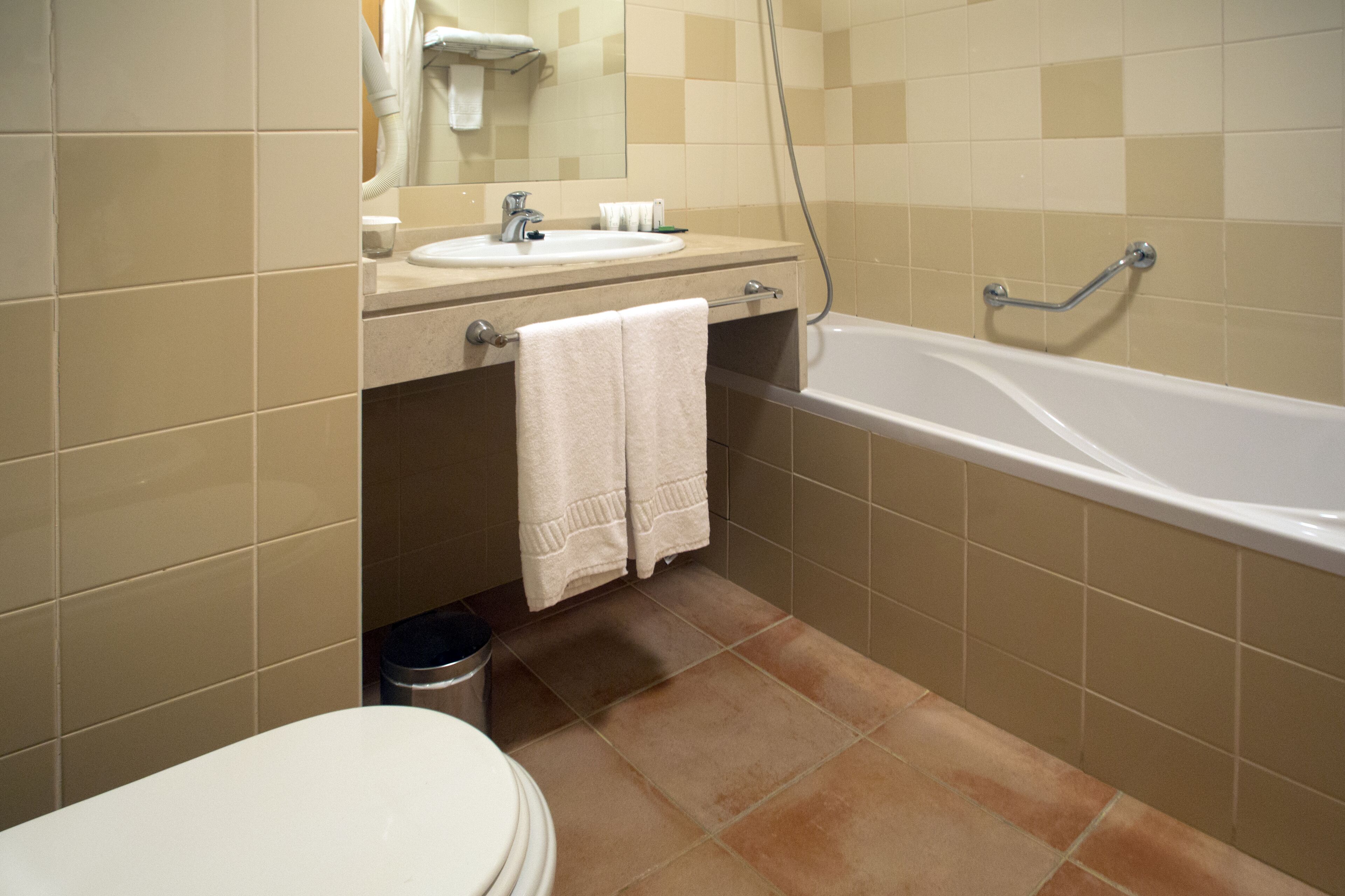 Une salle de bain avec un lavabo, un miroir et une baignoire.