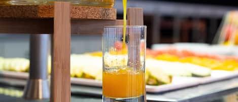 On verse un verre de jus d’orange à partir d’un robinet.