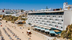 A hotel with multiple floors, outdoor seating areas, and a beachside location. - Hotel Sol e Mar - Adults Only (Albufeira)