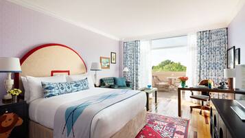 Habitación de hotel con una cama grande, un escritorio, una silla y vistas al exterior.
