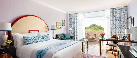 A hotel room with a large bed, a desk, a chair, and a view of the outdoors.