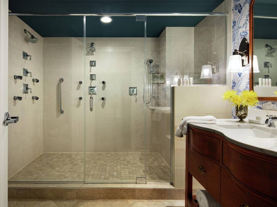 A modern bathroom with a glass-enclosed shower, a vanity with a mirror, and a sink.