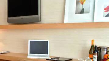 A kitchen with a laptop, a wine bottle, and a fruit bowl.