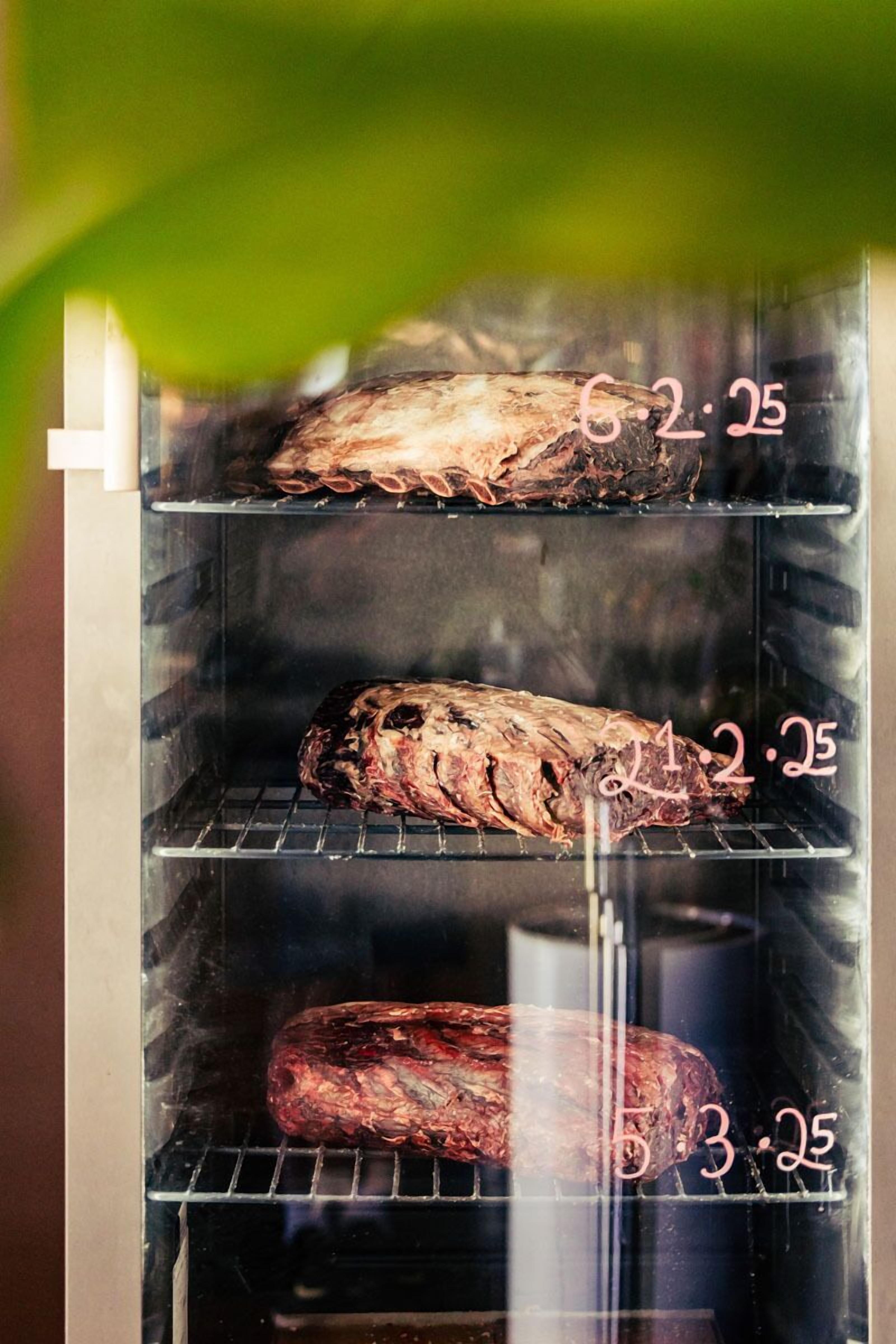 Vlees dat in een oven roostert, met zichtbare tijdsaanduidingen.