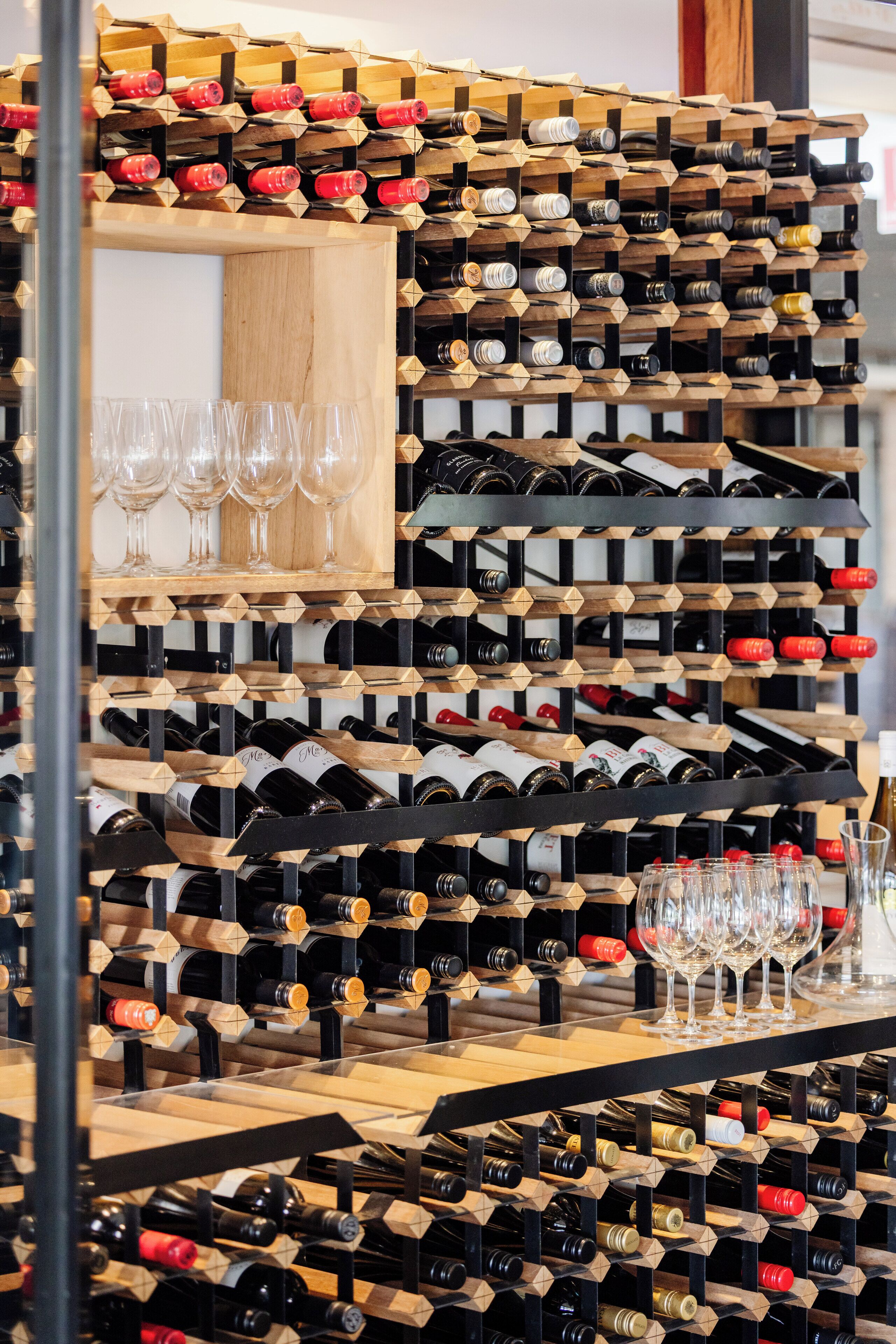 Un porte-bouteilles contenant plusieurs bouteilles et verres.