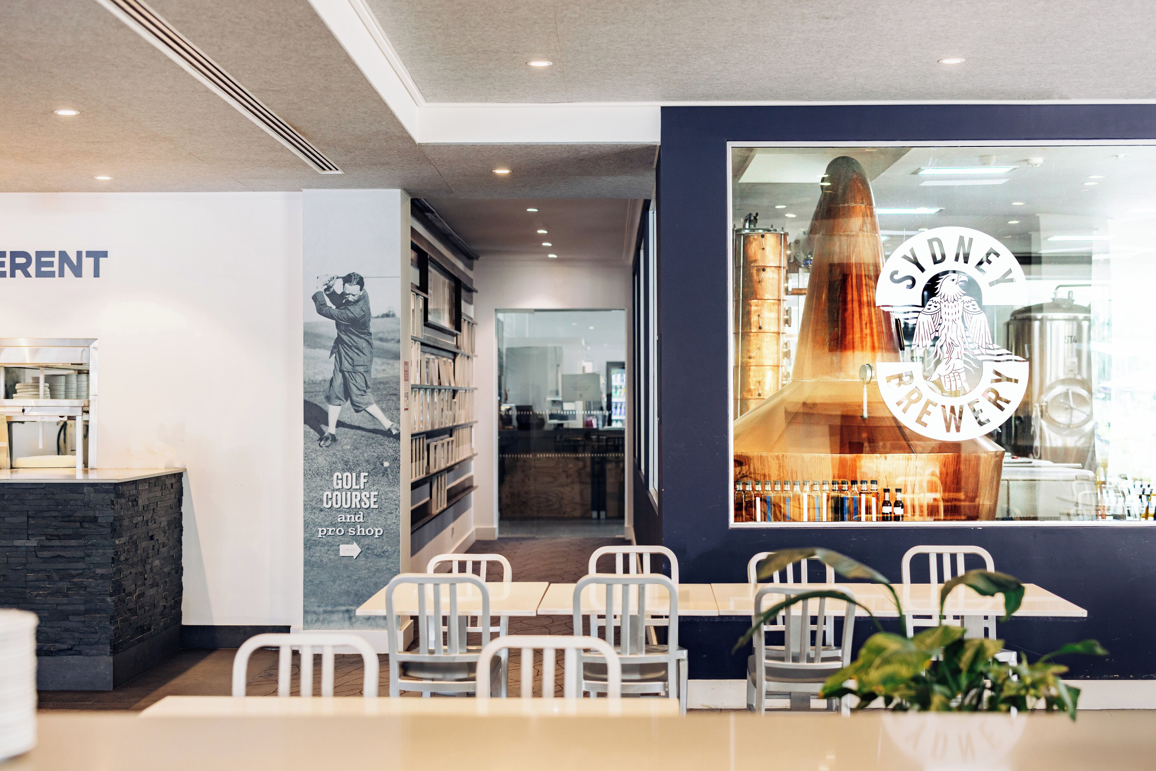 Un intérieur moderne comprenant un comptoir d’accueil, un espace détente et une grande fenêtre sur laquelle est affiché un logo.
