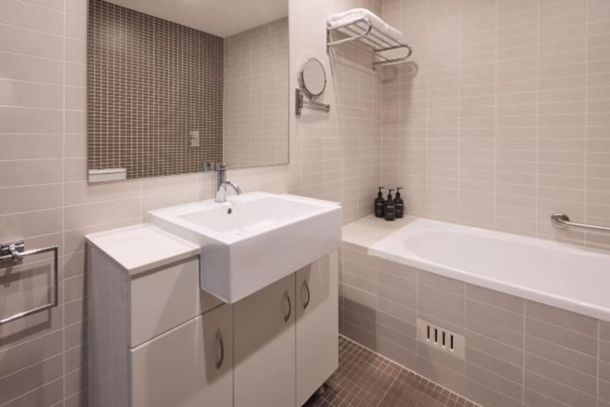 Ein modernes Badezimmer mit Waschbecken, Spiegel und Badewanne.