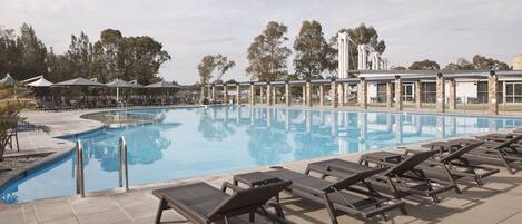 Una piscina con lettini e una zona coperta.