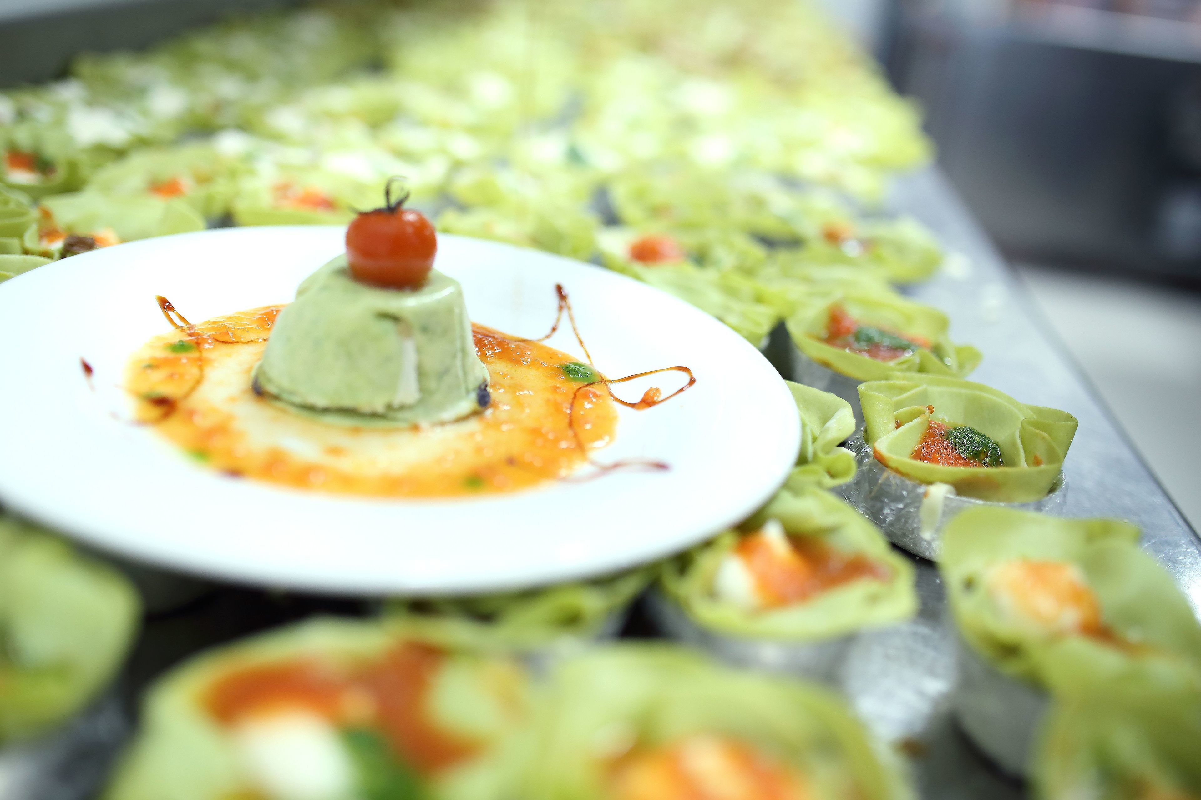A variety of dishes on a buffet table, including a central dish with a cherry on top and smaller dishes with different fillings.