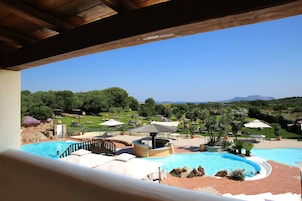 Una piscina con vista su un giardino curato e montagne lontane.