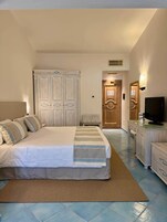 Una habitación de hotel con cama, televisor y escritorio.