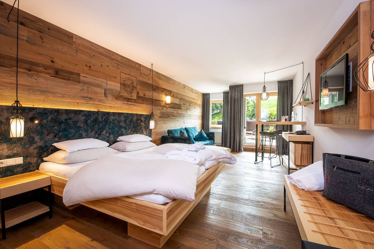 Ein Schlafzimmer mit einem hölzernen Bett, einem Schreibtisch und einem Fernseher.