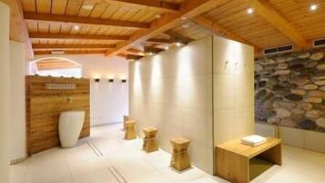Un moderno spa con vigas de madera, paredes de piedra y mobiliario minimalista.