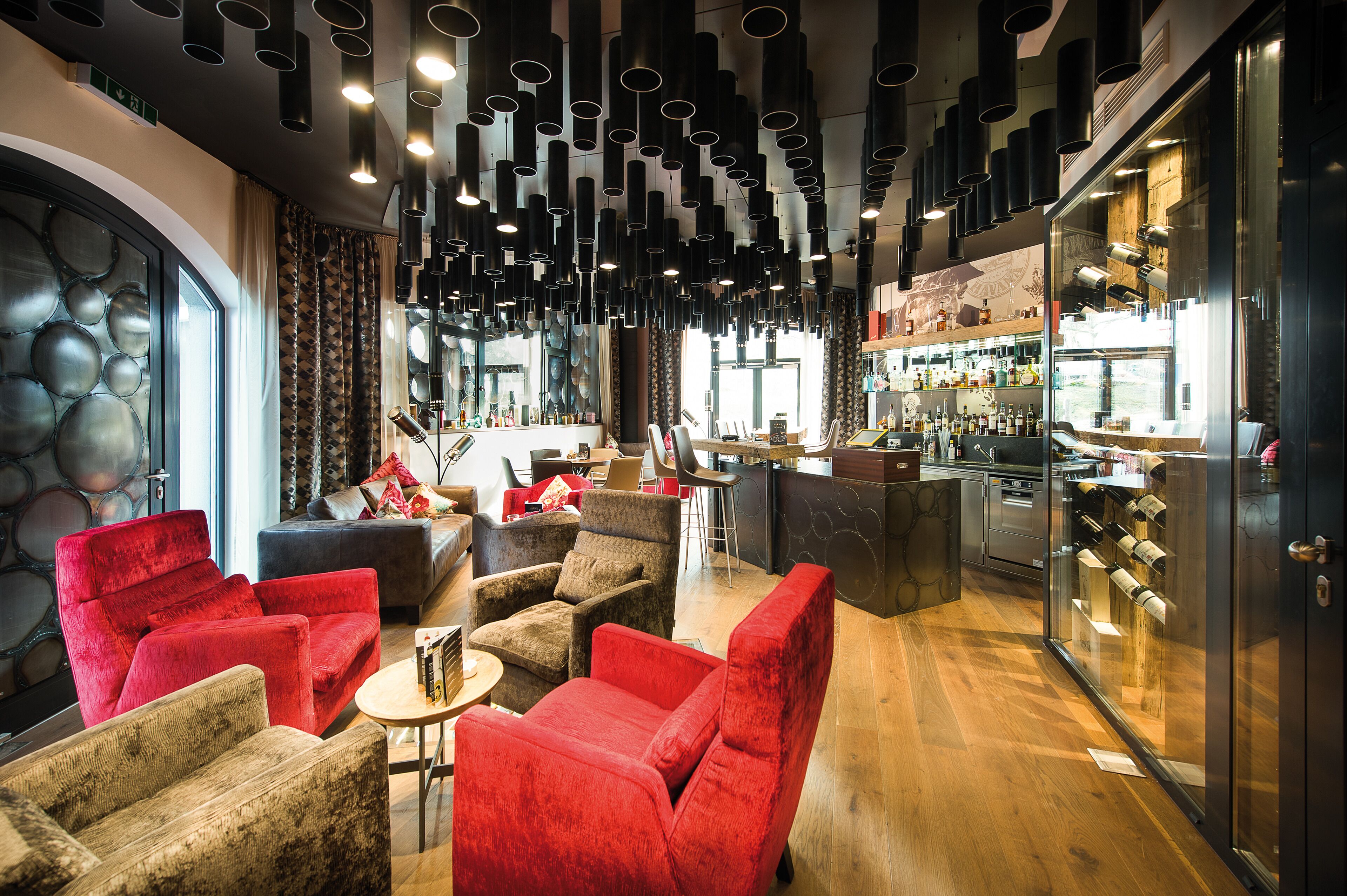 Ein modernes Interieur mit Sitzgelegenheiten, einer Bar und einer Weinauslage.