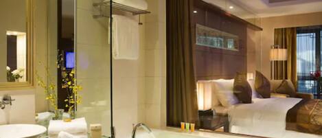 A modern hotel bathroom with a large mirror, a bathtub, and a sink.