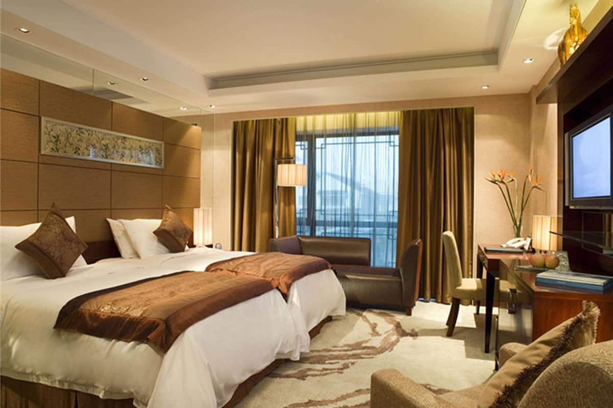 Une chambre d’hôtel avec un grand lit, un bureau et une télévision.