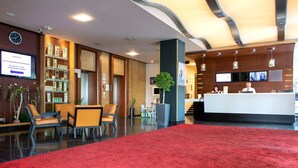 A modern hotel lobby with a reception desk, seating area, and a red carpet. - Novotel Budapest Danube (Budapest)