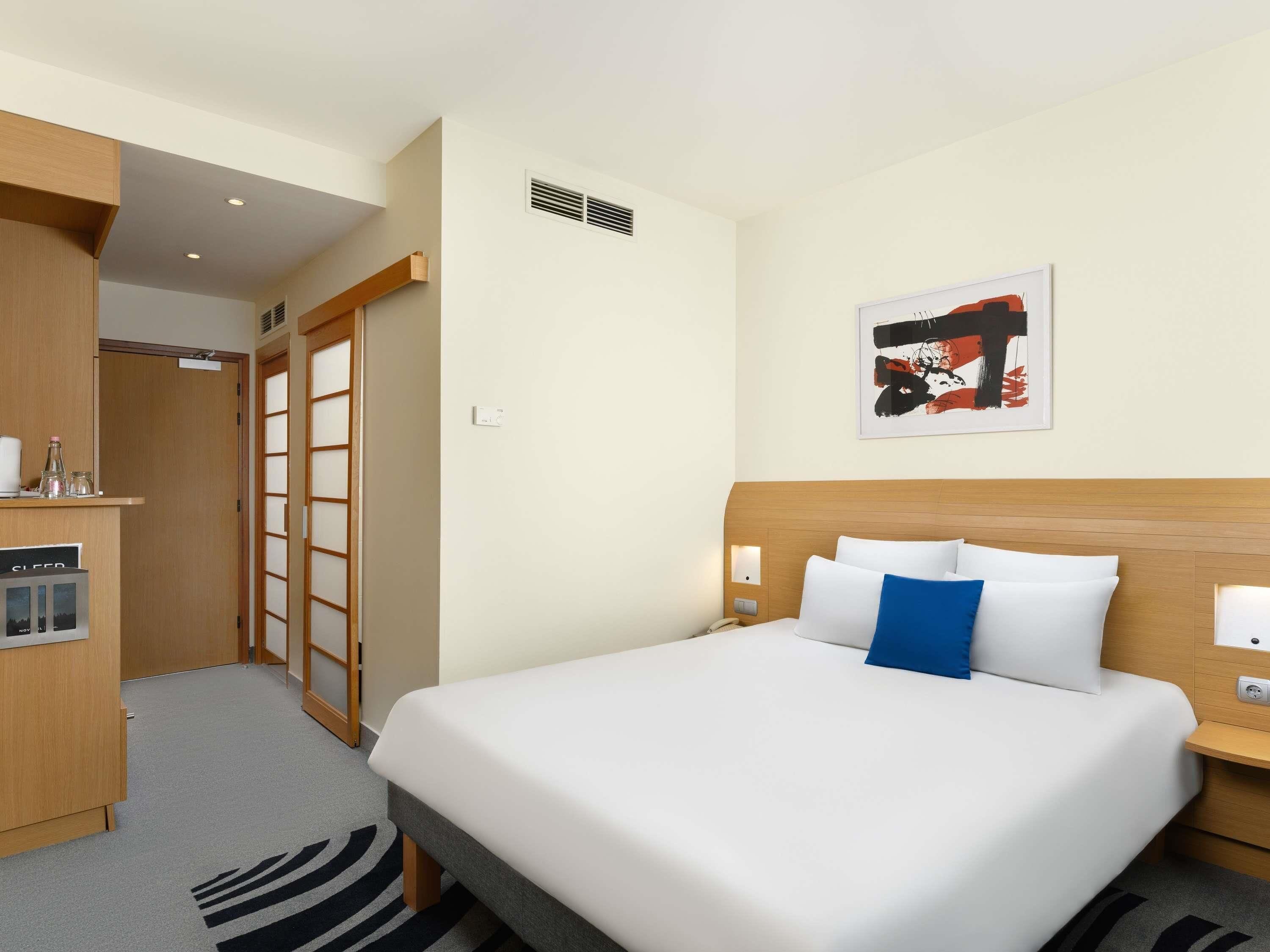 Una habitación de hotel con cama, mesitas de noche, escritorio y una silla.