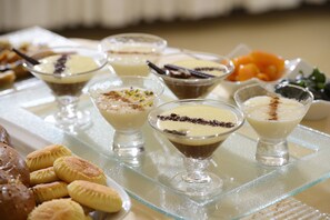 Una bandeja con diversos postres cremosos y pastelería.