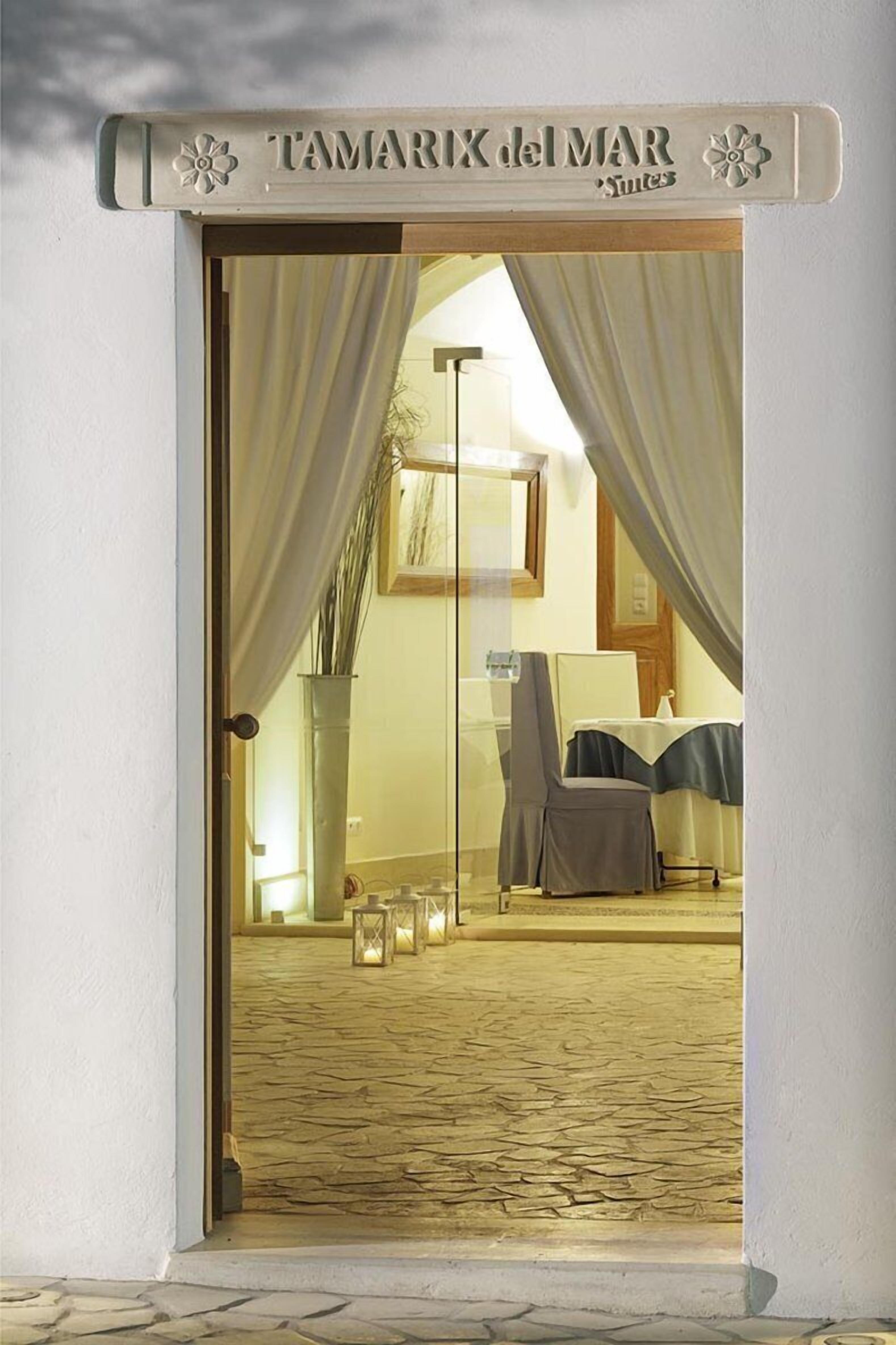 Una puerta con un letrero que dice "TAMARIX del MAR Suites".