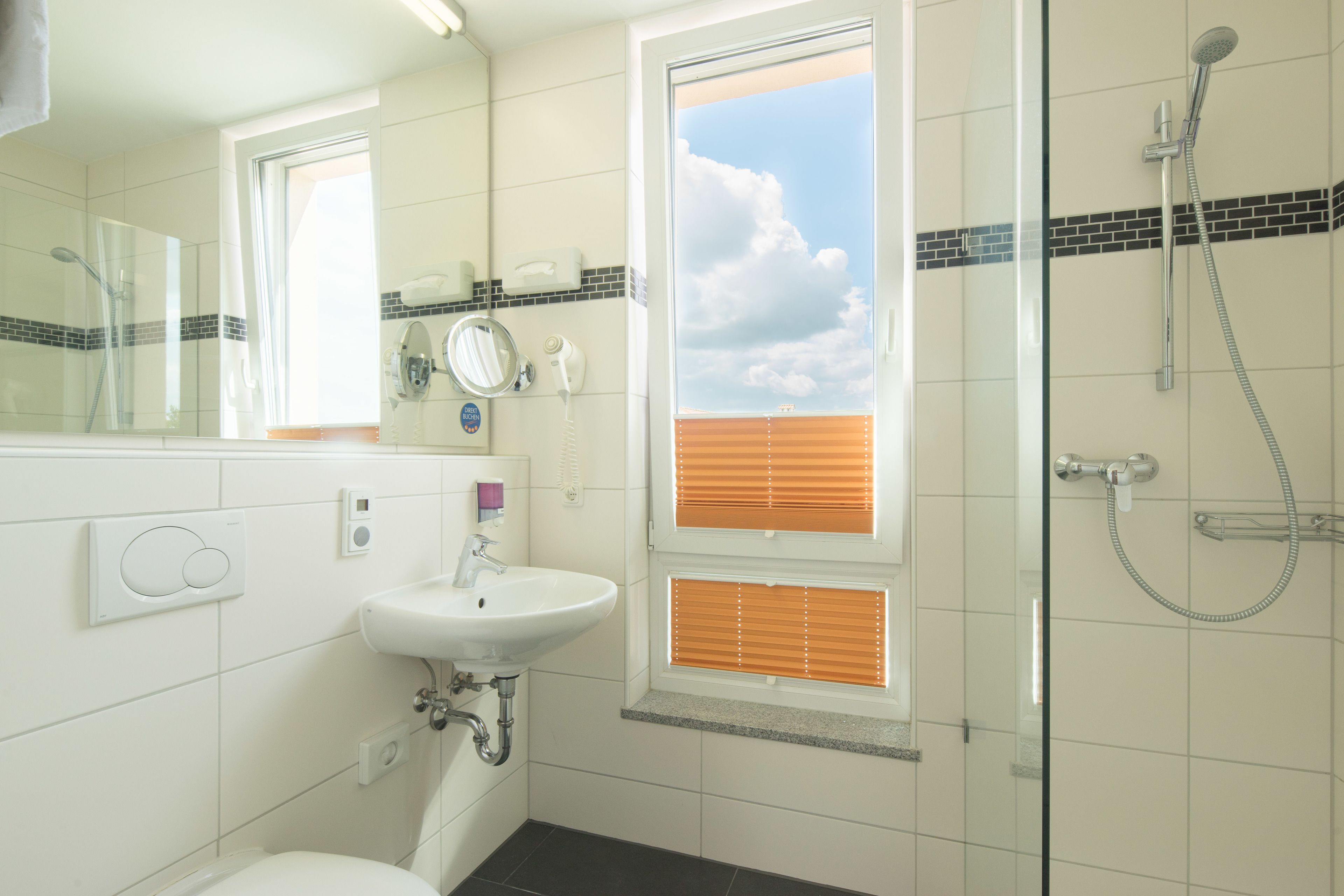 Ein Badezimmer mit Waschbecken, Spiegel und Dusche.